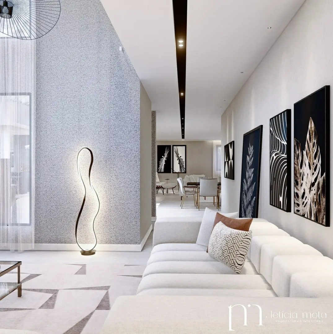 Galeria de estar do ambiente Passeio para a Casa, com painel de textura mineral e composição de quadros em preto e branco.